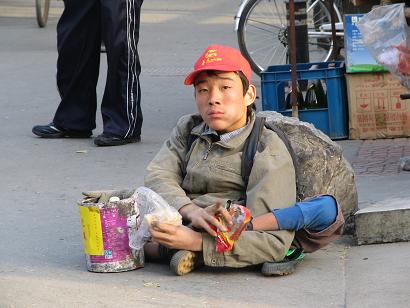 This disabled man was on the corner of a busy intersection begging for money. I have been told the government helps the disabled and they need not go onto the streets and beg. But maybe the government does not help enough. I tried to take the picture without him seeing me. I gave him a yuan, later after I took the picture. I put this picture up to show everyone what I have been seeing here.